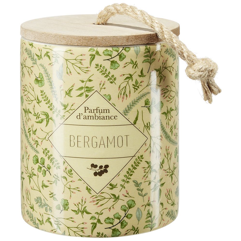 Candle in a ceramic pot with a plant design